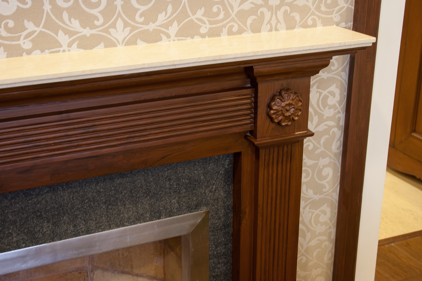 The fireplace is faced with flamed granite. The surround is of carved wood and the mantlepiece is polished marble.