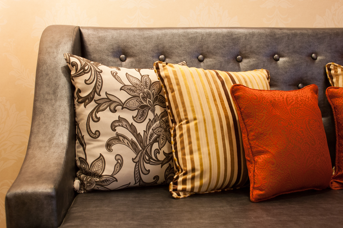 Colourful cushions accent the leather sofa.